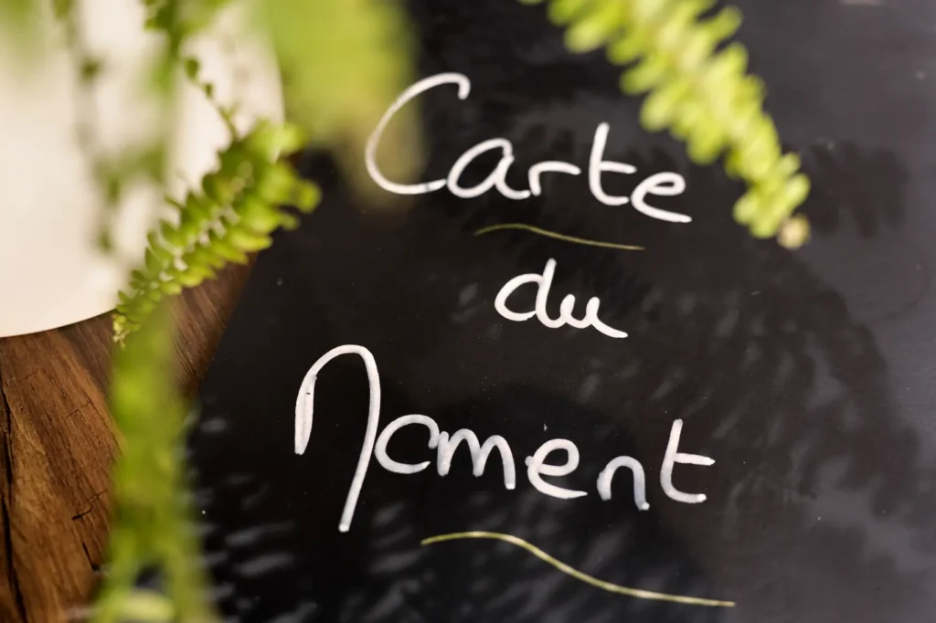 Un texte écrit sur une ardoise qui dit "Carte du moment"