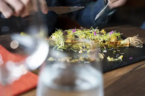 Une personne mange un plat dans le restaurant Le One